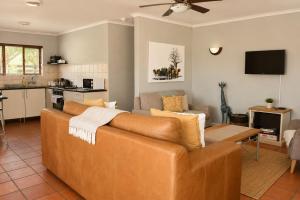 a living room with a brown couch and a kitchen at 26 on Greenway in White River