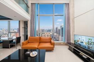 a living room with an orange couch and a large window at Louidon Mega Duplex Apartment - Beijing Rd in Guangzhou