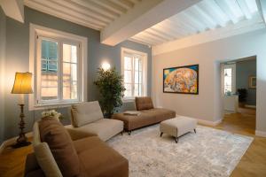 a living room with a couch and chairs and windows at Anfiteatro - Spacious and elegant residence in Lucca