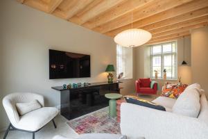 a living room with a couch and a table and chairs at Entre Pierres et Rivière - 2 Gites avec wellness privatifs in Hotton