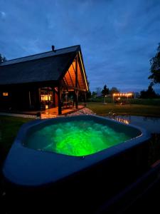 a large pool of green water in front of a building at Mihkliranna Puhkemaja in Marksa