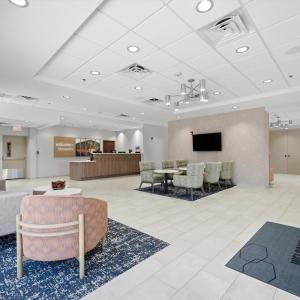 a lobby with a waiting room with a table and chairs at Hampton Inn Inwood in Inwood