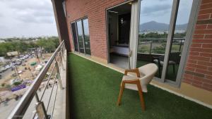a balcony with a chair and green grass at Hotel Divine in Junagadh