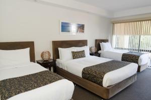a hotel room with two beds and a window at Bay Motel Safety Beach in Safety Beach