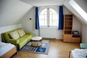 Una sala de estar con un sofá verde y una ventana. en Apartments Haus Eintracht Sellin, en Ostseebad Sellin