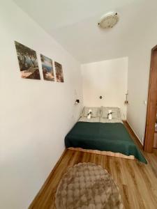 a bedroom with a bed with a green bedspread at Thermal Oazis Apartman in Mosonmagyaróvár