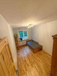a bedroom with a bed in a room with wooden floors at Pine Apartment, Riga in Riga