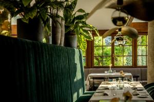 a dining room with tables and plants and windows at Hotel Magdalener Hof in Bolzano +127 photos
