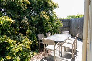 a table and chairs sitting on a patio at Bay Motel Safety Beach in Safety Beach +18 photos