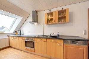 a kitchen with wooden cabinets and a sink at Am Fabianstift 1 in Hornbach