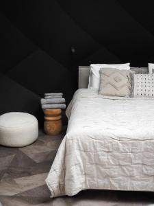 a bedroom with a white bed and a black wall at Taju Resort in Manniva