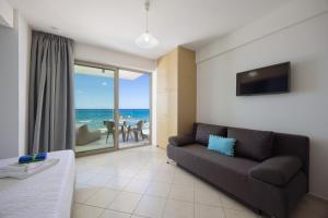 a living room with a couch and a view of the ocean at SEPERI Deep Blue in Rethymno