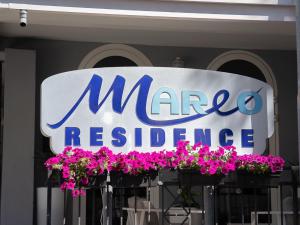 a sign for a marco reedence store with pink flowers at Residence Mareo in Riccione