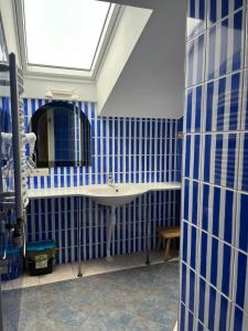 a bathroom with blue tiled walls and a sink at Lindaga in Ragaciems