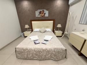 a bedroom with a large bed with two towels on it at S'Agapo Maisonette St' Julians in St. Julianʼs