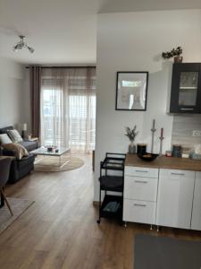 a living room with a couch and a table at Lily Beach Apartman in Balatonlelle