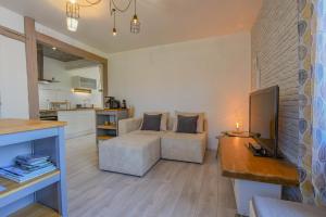 a living room with a couch and a kitchen at La louvière in Jeugny