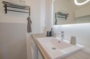 a white bathroom with a sink and a mirror at La louvière in Jeugny +7 photos
