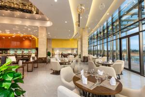 a restaurant with tables and chairs and windows at DIC Star Villas Vinh Phuc in Vị Trù