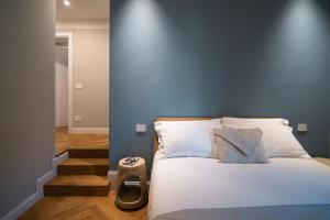 a bedroom with a bed with a blue wall at Anfiteatro - Spacious and elegant residence in Lucca