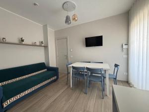 a living room with a couch and a table and chairs at Micabalù Luxury Apartment in Marina di Camerota