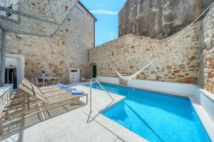 a swimming pool in a building with a brick wall at Villa Majestic with heated pool and rooftop terrace in Bol