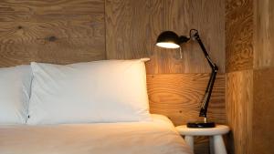 a lamp sitting on a table next to a bed at Capella Oceanview Spa Resort – Goseong in Goseong