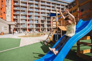 a young boy riding on a slide at a playground at Hotel Akvamarín in Bešeňová
