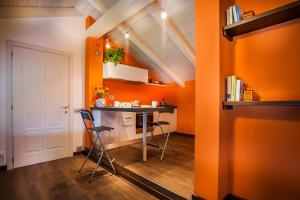 una pequeña cocina con paredes de color naranja, mesa y sillas en Arc en Ciel Appartments, en Cocconato