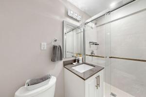 a white bathroom with a sink and a shower at The Boxwood Executive Suite in Markham +37 photos