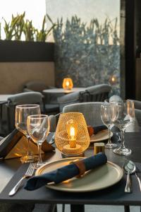 a table with a plate with a candle and wine glasses at Punto Suites Periférico Sur in Mexico City