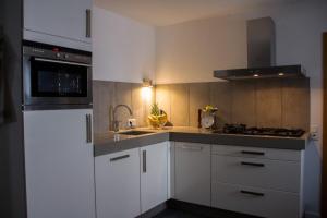 a kitchen with white cabinets and a sink and a stove at Ferienwohnung Götzis in Götzis