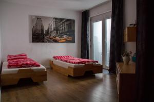 two beds in a room with red pillows at Ferienwohnung Götzis in Götzis