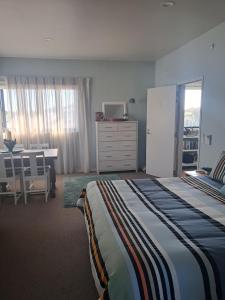 a bedroom with a bed and a dresser and a desk at Headlands Hotel in Opunake