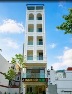 a tall white building with a sign in front of it at Morgan Hotel in Ấp Bình Hưng