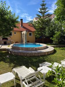 a swimming pool with a fountain in a yard at Apartment Orange Blossom First Line & Pool 1 in Bijela