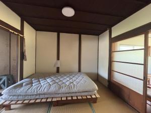 a bedroom with a bed in a room with a window at Aoi-Yane Traditional Japanese House in Kumano Kodo Nakahechi in Tanabe