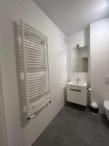 a white bathroom with a toilet and a sink at Cube Apartamenty in Lublin +171 photos