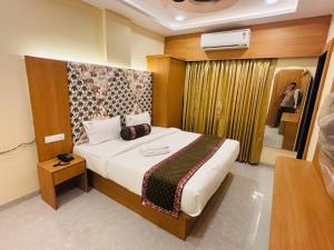 a bedroom with a bed in a room with a window at Hotel Rajwada Nagpur in Nagpur
