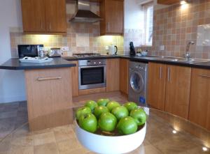 a kitchen with a bowl of green apples in it at St Raphael House, City Centre Charming Apartments in Basingstoke