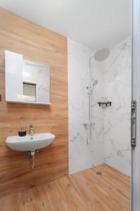 a white bathroom with a sink and a shower at Къща за гости Сирената in Sozopol +64 photos