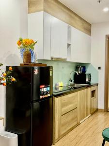 a kitchen with a black refrigerator and a sink at QM House 08 in Hanoi