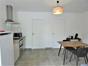 a kitchen with a table and chairs in a kitchen at Le clémens in Herm +11 photos