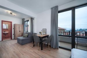 a living room with a table and a couch at Къща за гости Сирената in Sozopol