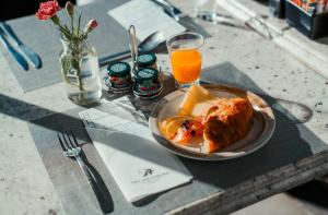 a plate of food on a table with a glass of orange juice at The Weinberg Windhoek in Windhoek