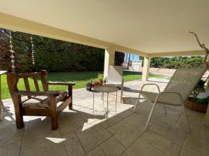 a patio with a chair and a table and chairs at Villa Zose' luz in Káto Ássos