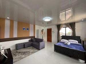 a bedroom with a bed and a couch at Stay at Diez in Calamba