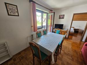 a dining room with a table and chairs and a window at Bohinjski kot in Bohinj