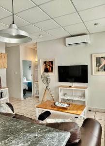 a living room with a tv and a table at The Tipsy Expat - Paarl - Self Catering Apartment in Paarl