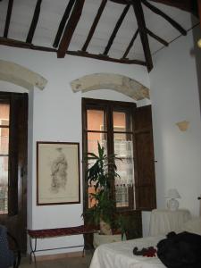 una camera da letto con pareti e finestre bianche e una pianta di Guest House Il Giardino Segreto a Cagliari